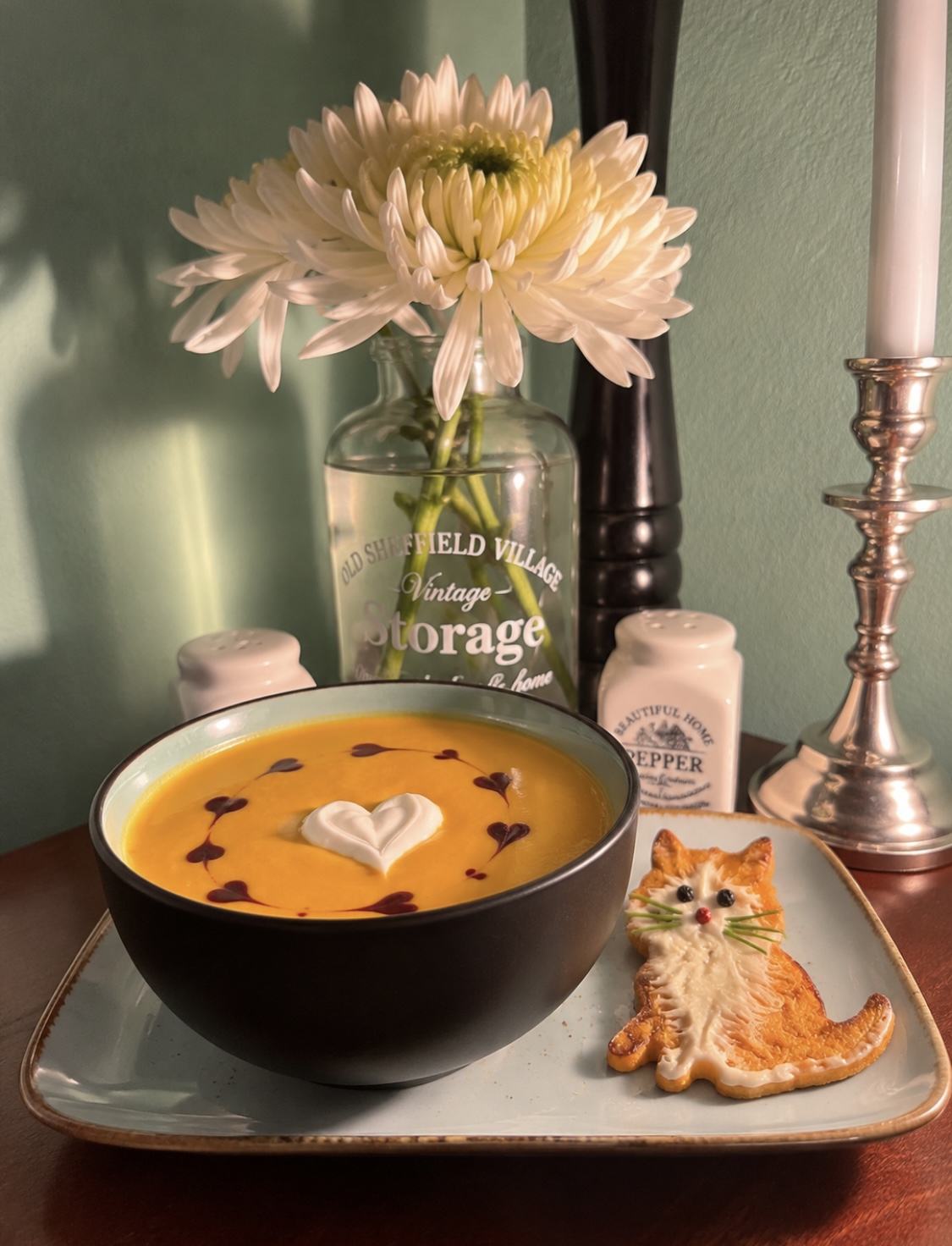 Creamy vegan roasted Hokkaido pumpkin soup with fresh orange, ginger and Madras curry, garnished with vegan sour cream, pumpkin seed oil and homemade cat-shaped pumpkin fritters.